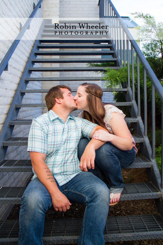 Engaged couple sitting together on a stairway, kissing