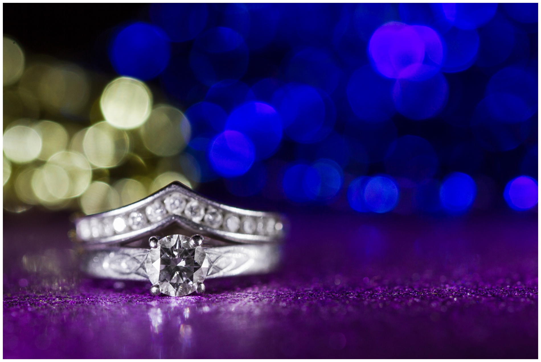 Beautiful blue and gold bokeh behind a wedding ring, with purple bokeh in the foreground