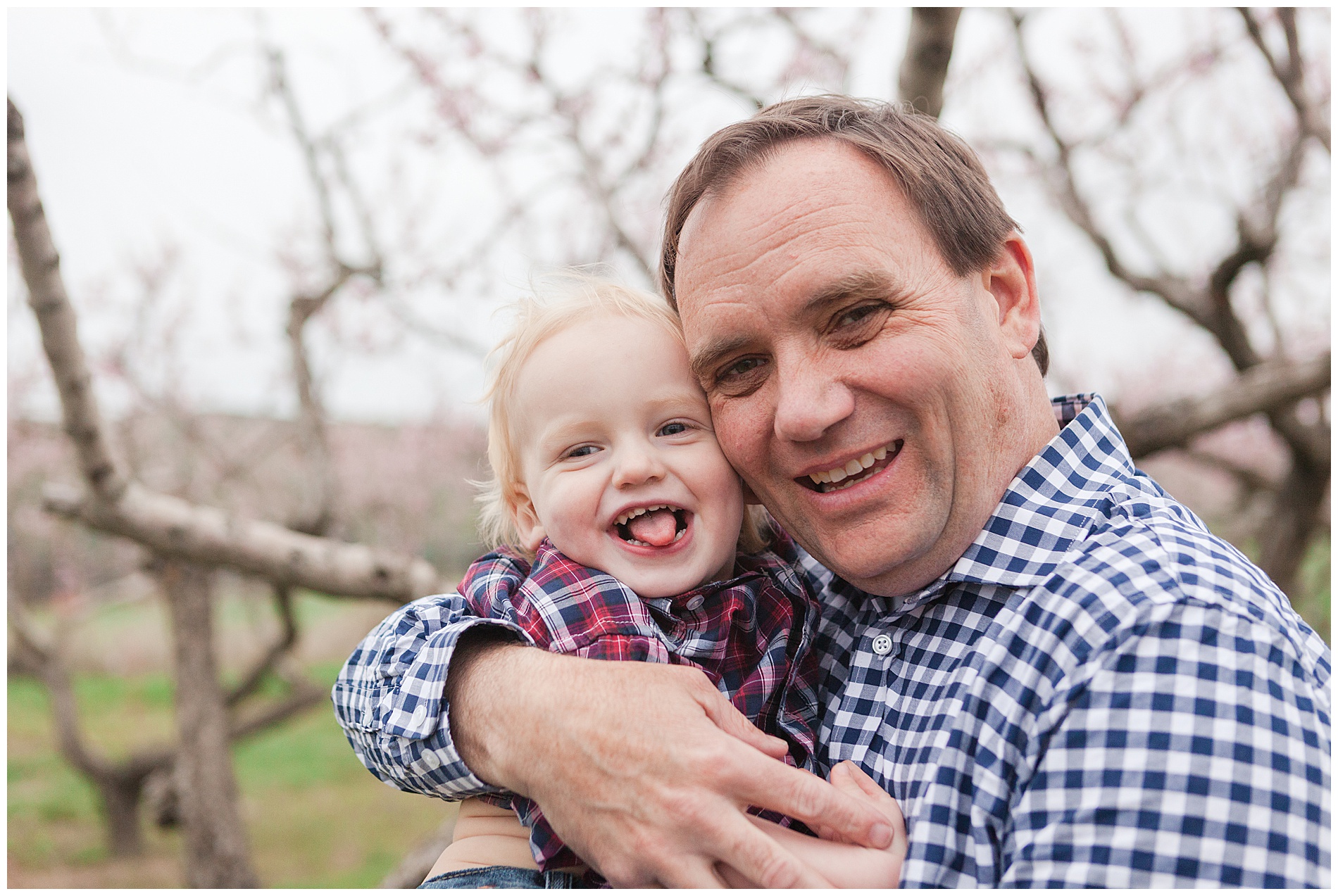 Fun and relaxed family portraits in a peach orchard with pink blossoms | Idaho family photographer | Robin Wheeler Photography