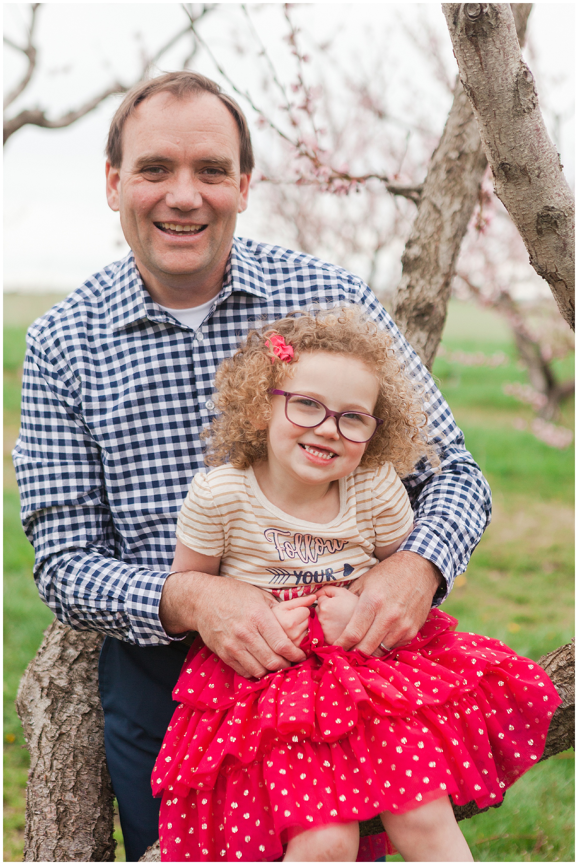 Fun and relaxed family portraits in a peach orchard with pink blossoms | Idaho family photographer | Robin Wheeler Photography