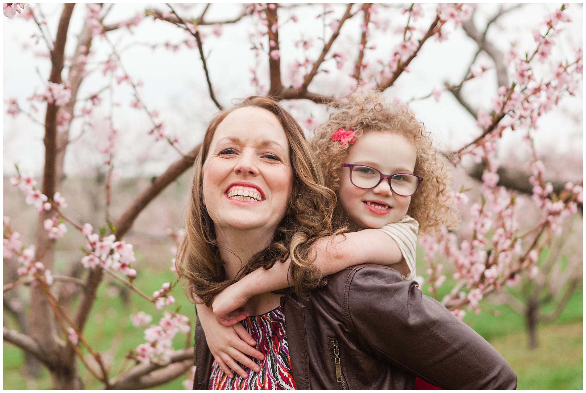 Fun and relaxed family portraits in a peach orchard with pink blossoms | Idaho family photographer | Robin Wheeler Photography