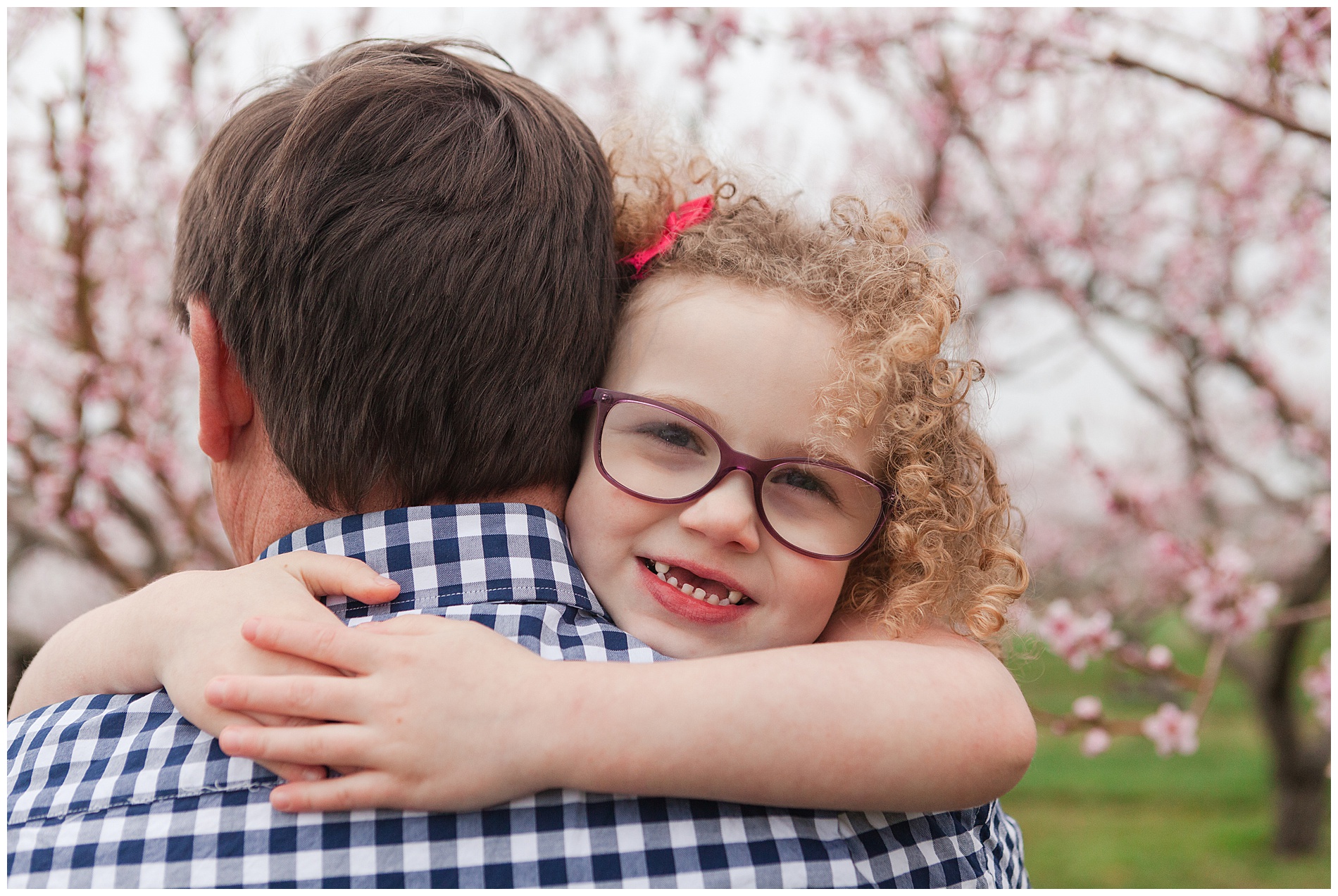 Fun and relaxed family portraits in a peach orchard with pink blossoms | Idaho family photographer | Robin Wheeler Photography