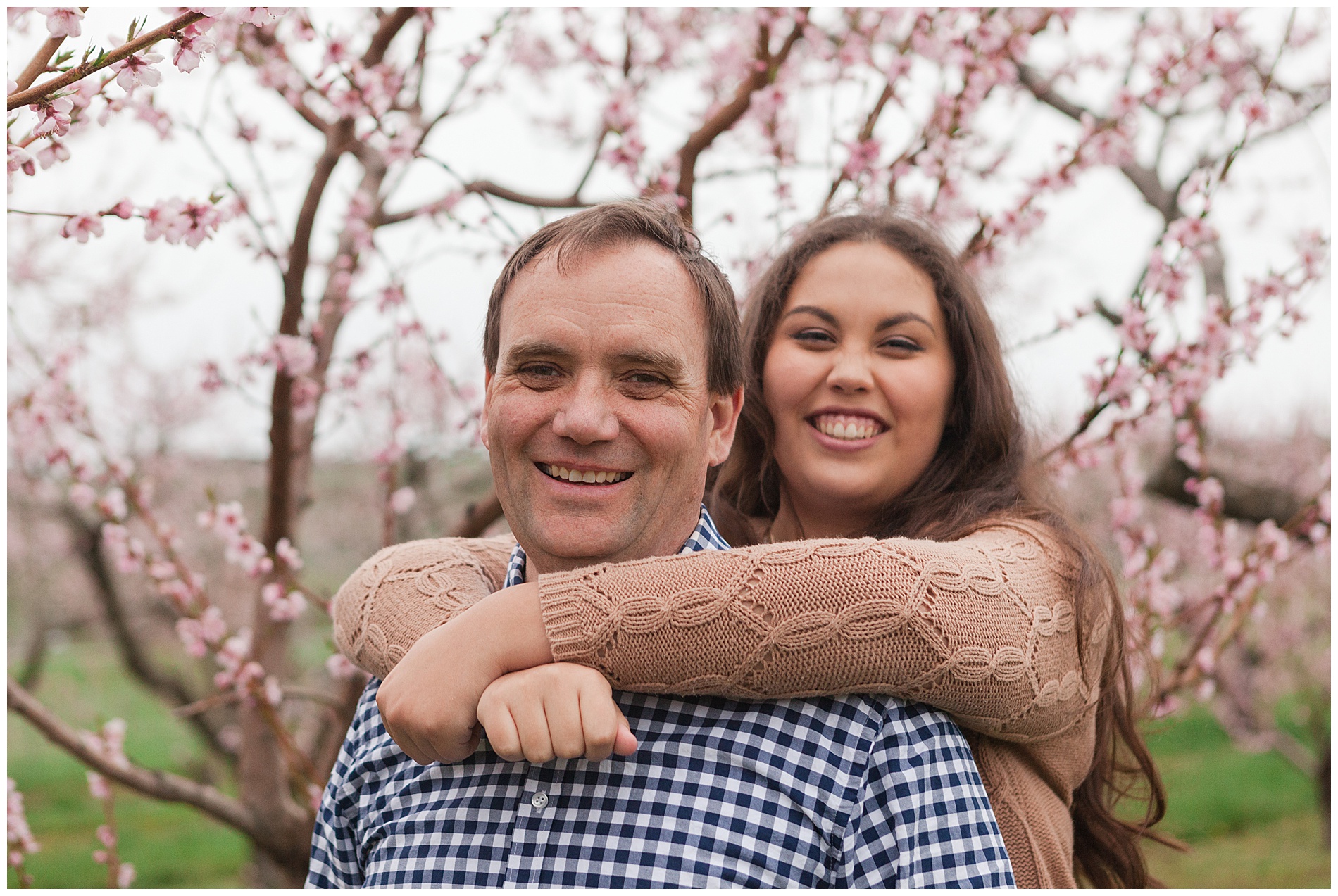 Fun and relaxed family portraits in a peach orchard with pink blossoms | Idaho family photographer | Robin Wheeler Photography