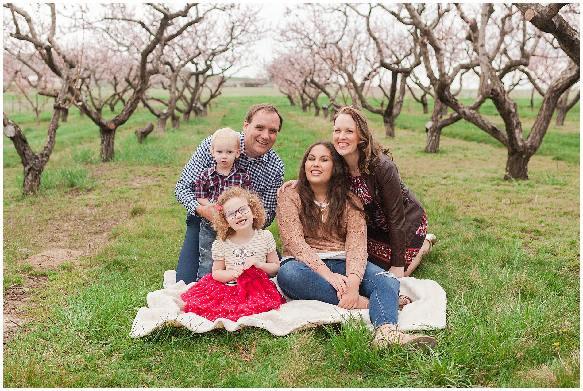 Fun and relaxed family portraits in a peach orchard with pink blossoms | Idaho family photographer | Robin Wheeler Photography