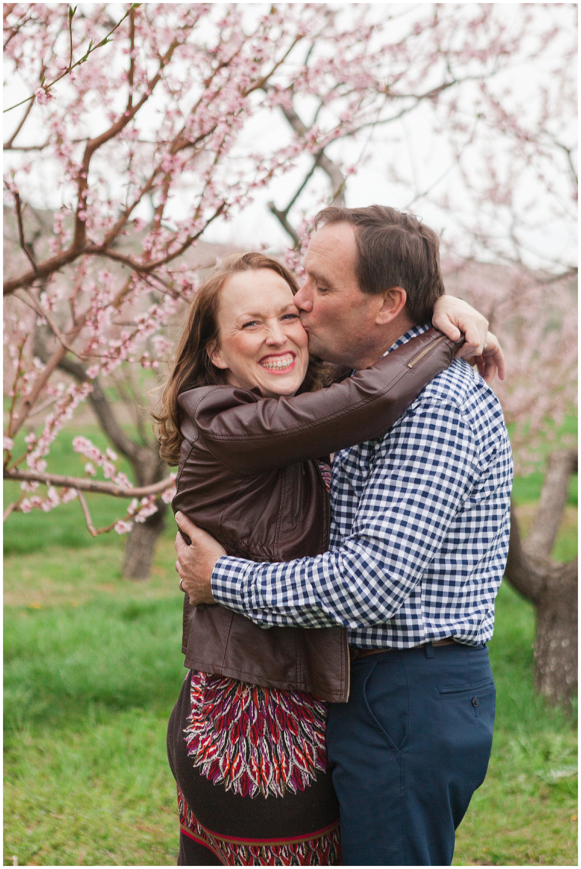 Fun and relaxed family portraits in a peach orchard with pink blossoms | Idaho family photographer | Robin Wheeler Photography