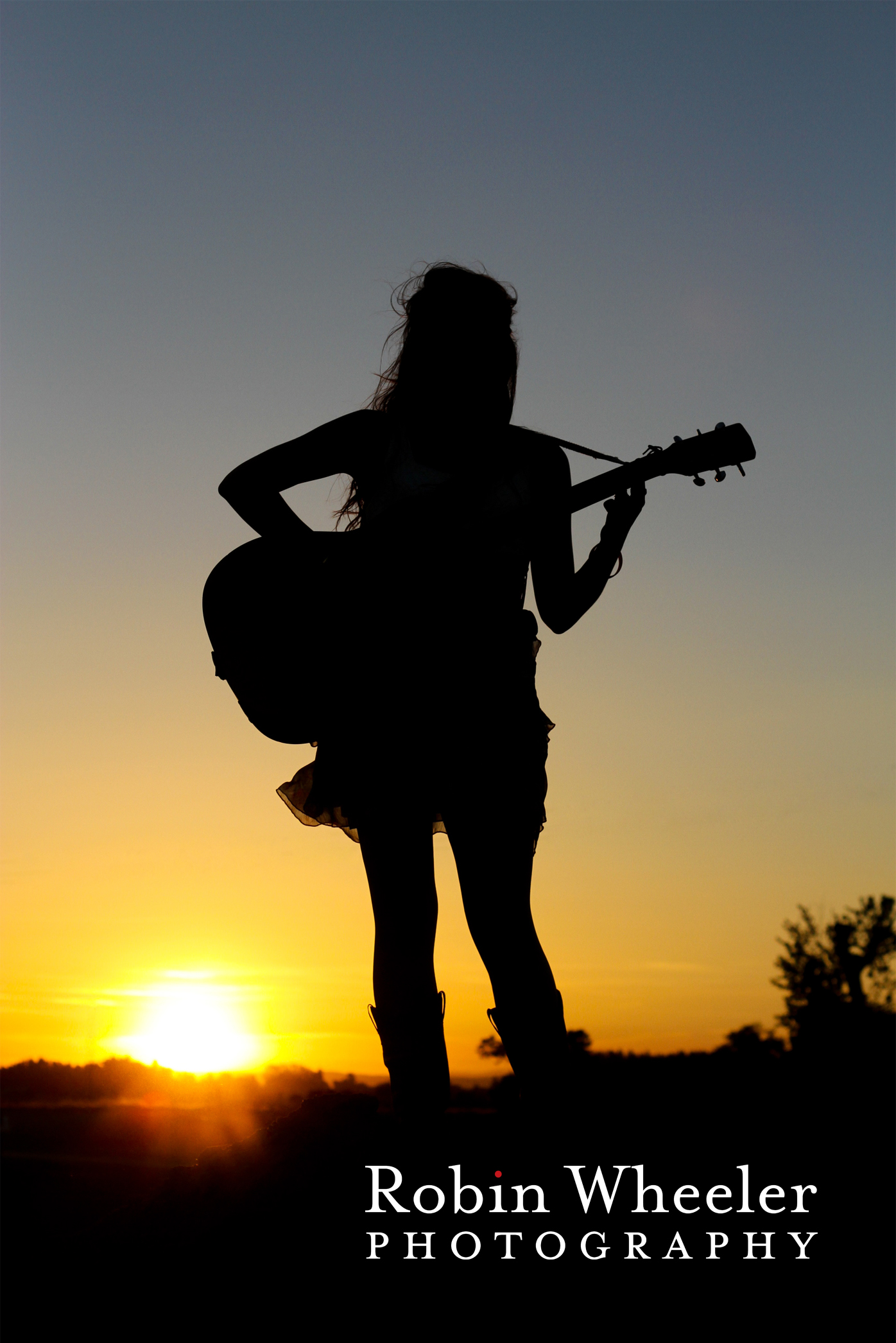 Senior photo of a girl with her guitar in silhouette at sunset, Fruitland, Idaho