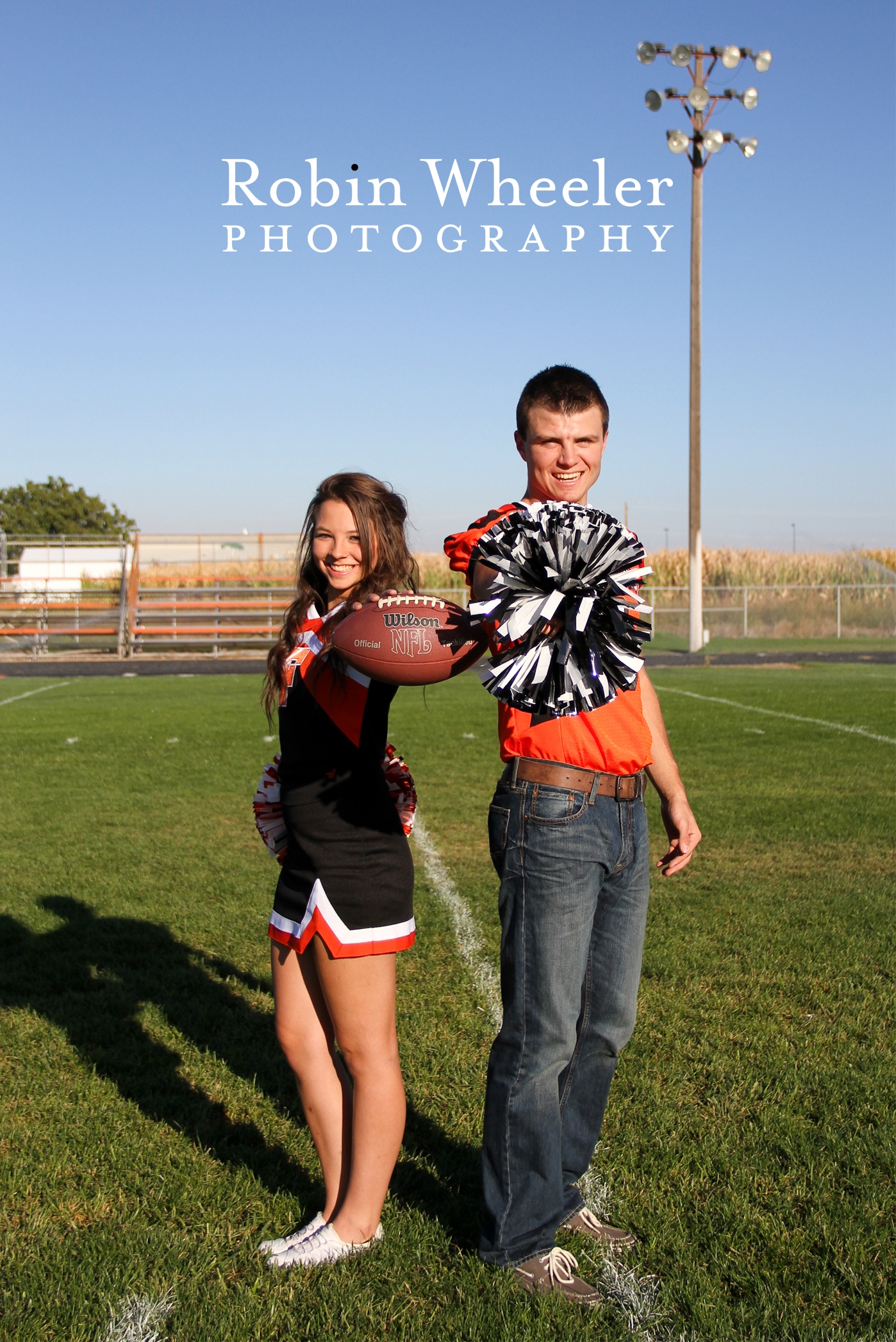 High school cheerleader holding a football and football player holding pom pom