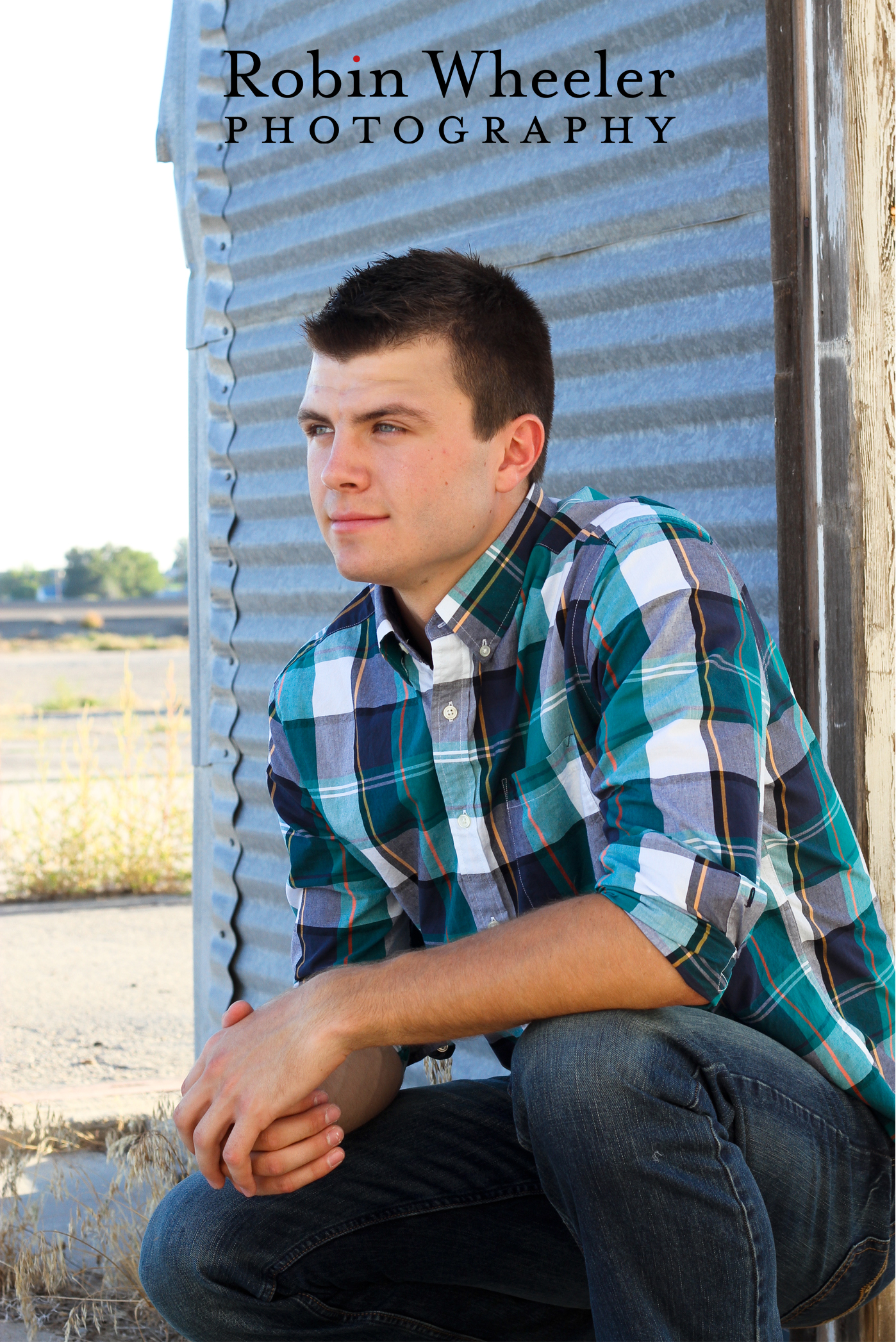 Senior boy in front of metal shed in rural Fruitland, Idaho