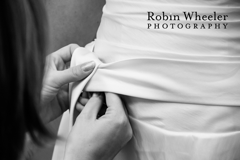 Bridesmaid tying the bride's dress before the wedding, Ontario, Oregon