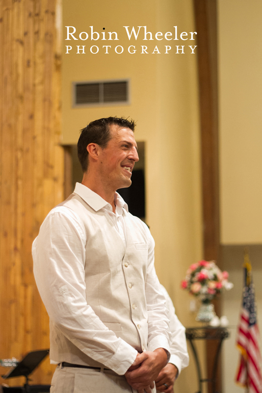 Groom looking on happily during wedding ceremony, Ontario, Oregon