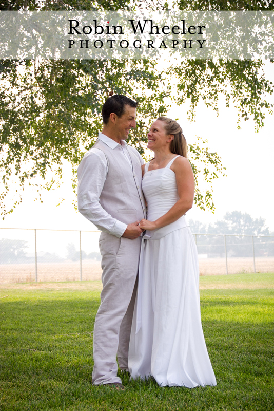 Groom and bride standing under a tree, Ontario, Oregon