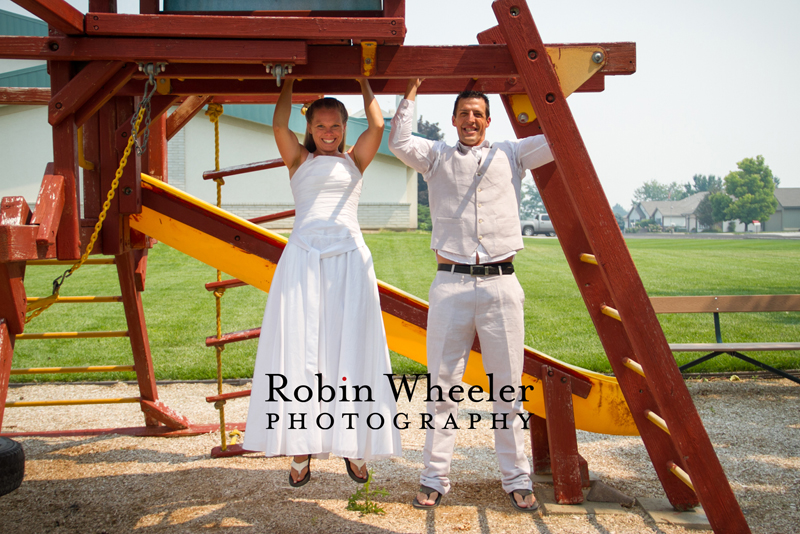 Crossfit bride and groom hanging from monkey bars on a playground, Ontario, Oregon