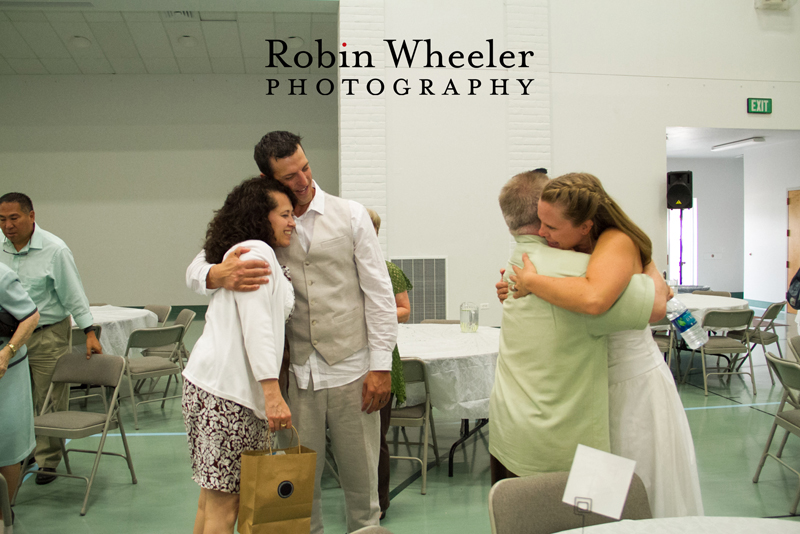 Groom and bride hugging wedding guests, Ontario, Oregon