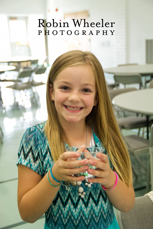 Girl holding a cup of confetti during the wedding reception, Ontario, Oregon