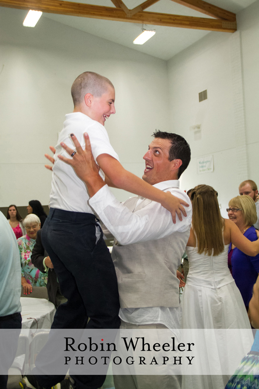 Groom tossing his nephew in the air during the wedding reception, Ontario, Oregon