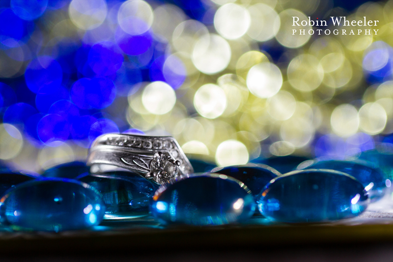 macro photo of a wedding ring with blue and gold bokeh