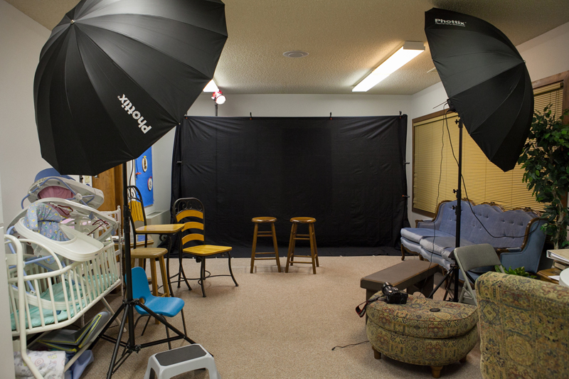 two bar stools set up in front of a photography backdrop