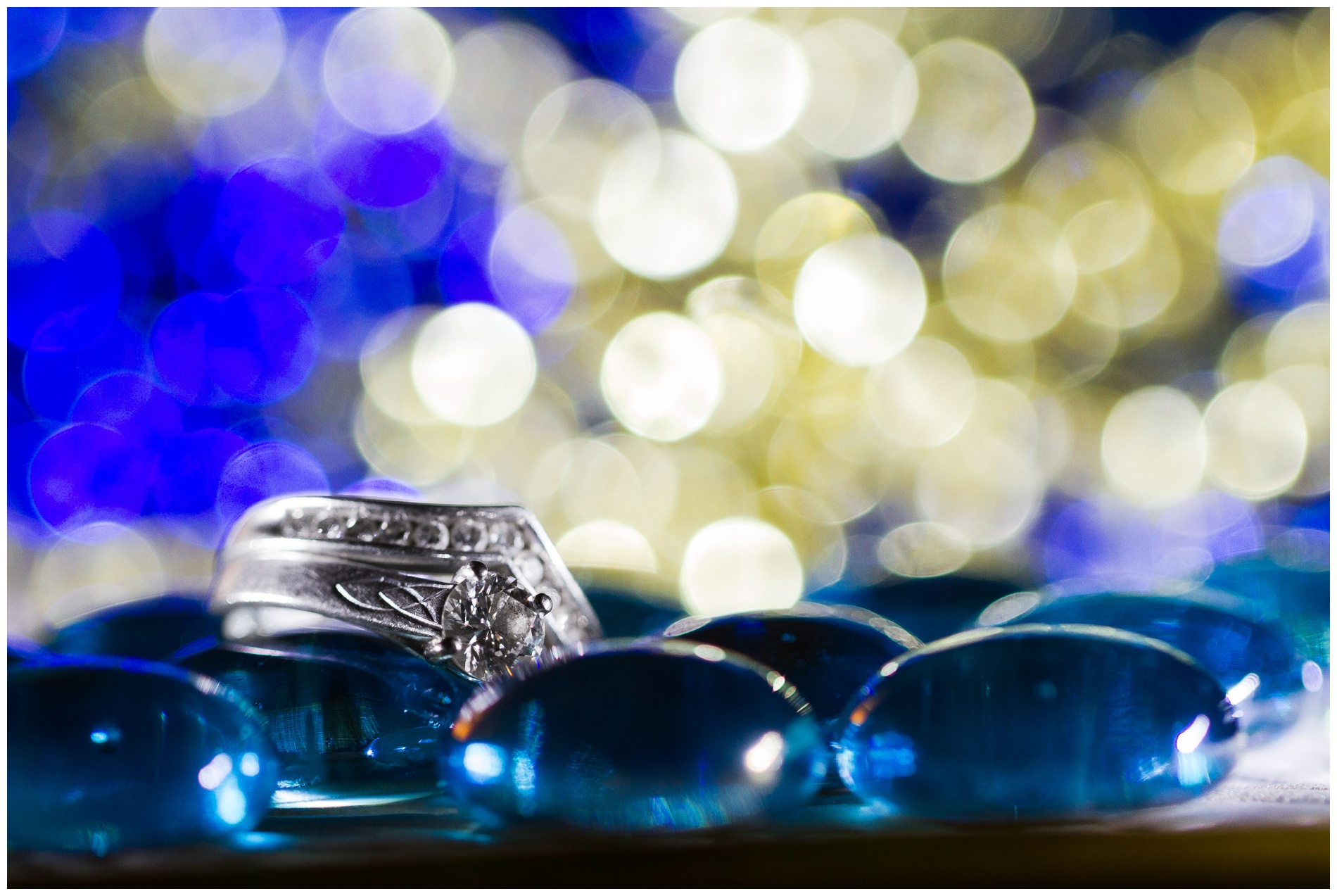 Beautiful blue and gold bokeh behind a wedding ring