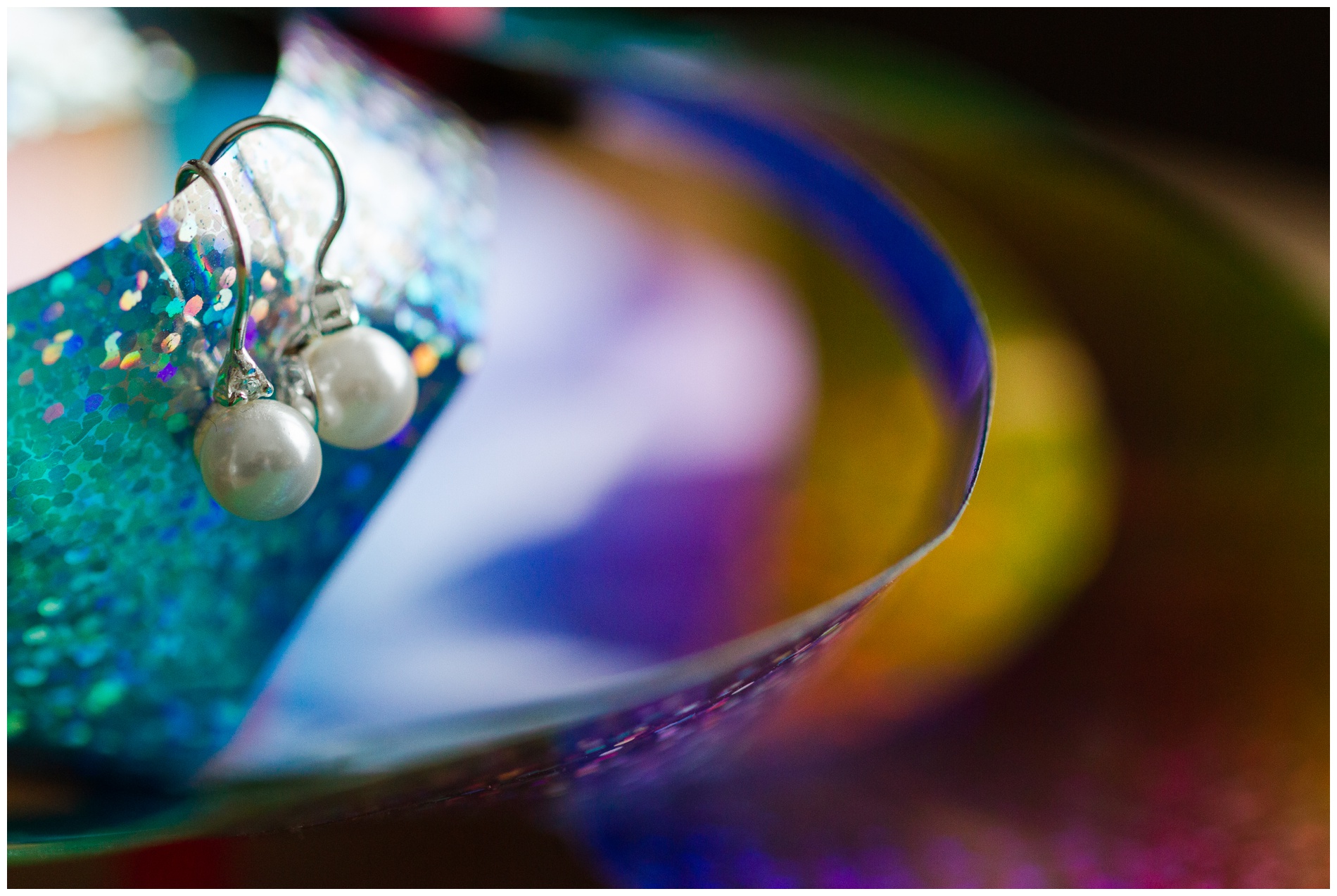 Pearl and diamond fishhook earrings on a pinwheel