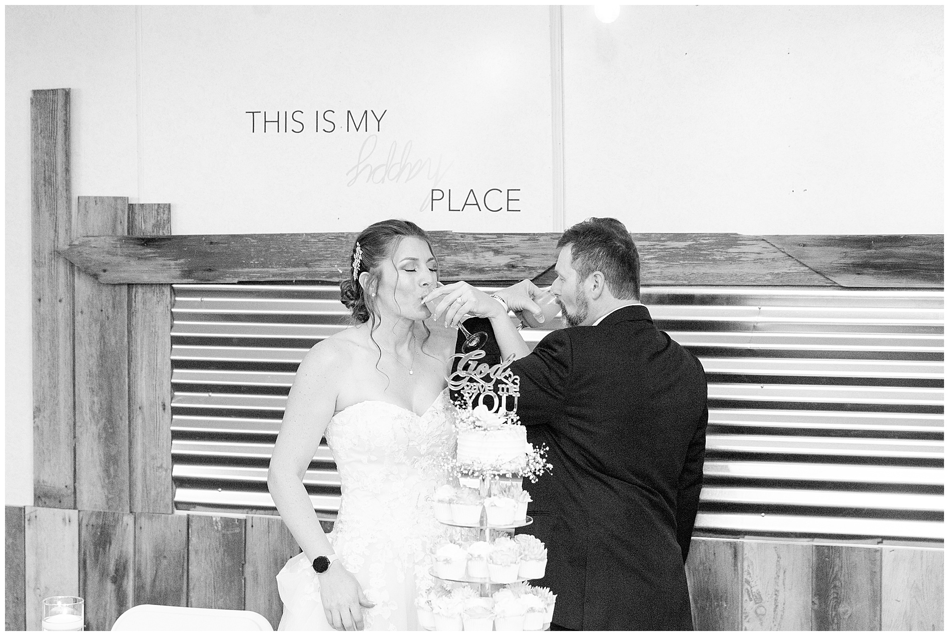 The bride and groom drink from their glasses with arms entwined