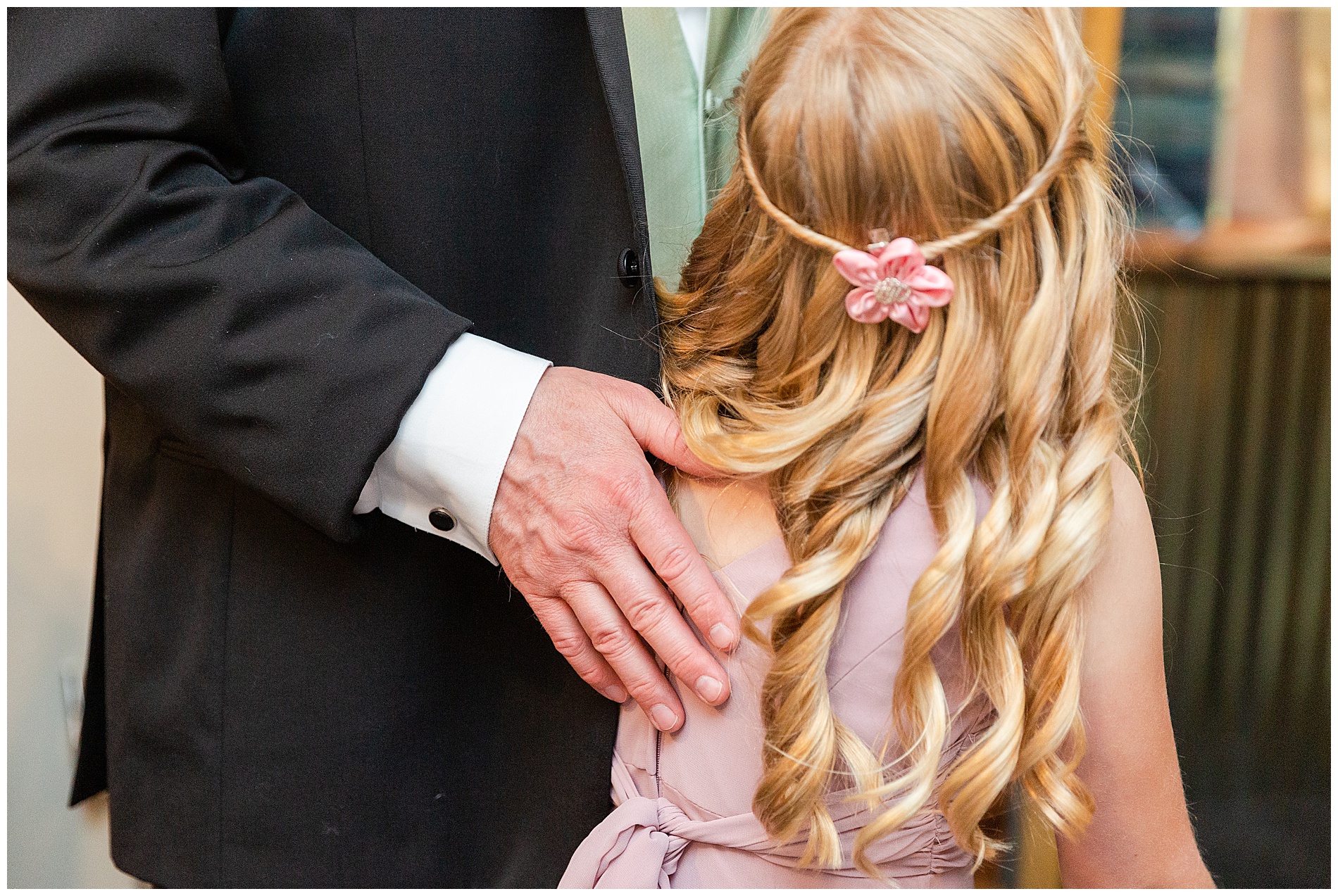 The groom's hand on his daughter's shoulder