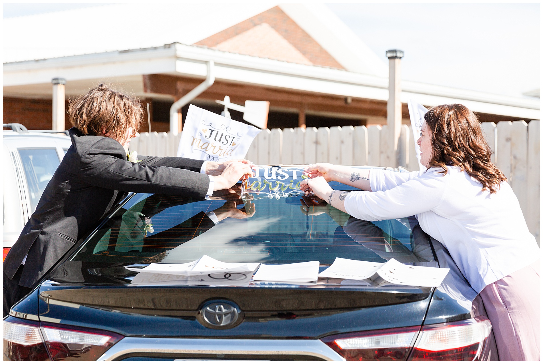 The bride's children decorate the getaway car with window clings