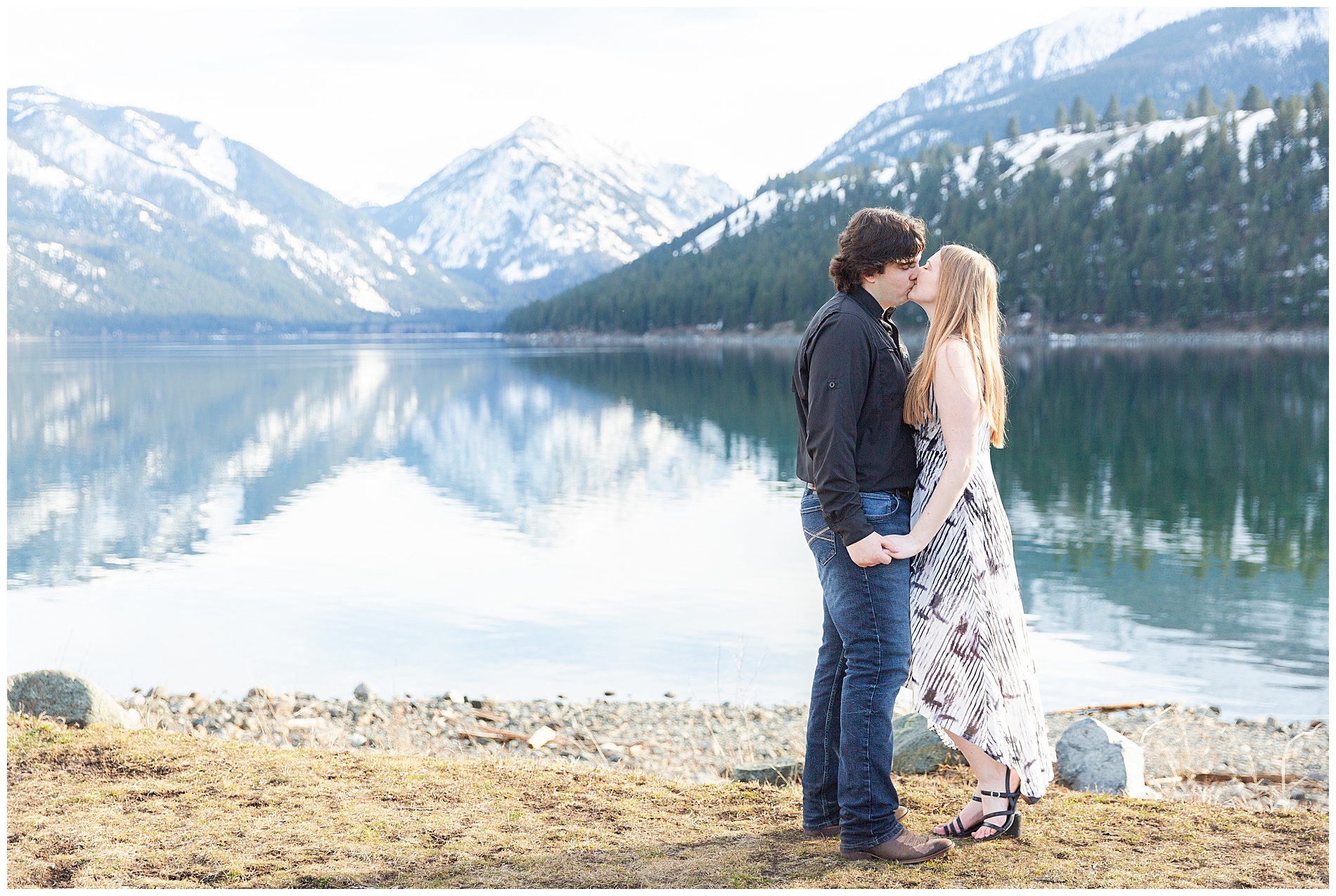 Engaged couple kissing on the shore of Wallowa Lake