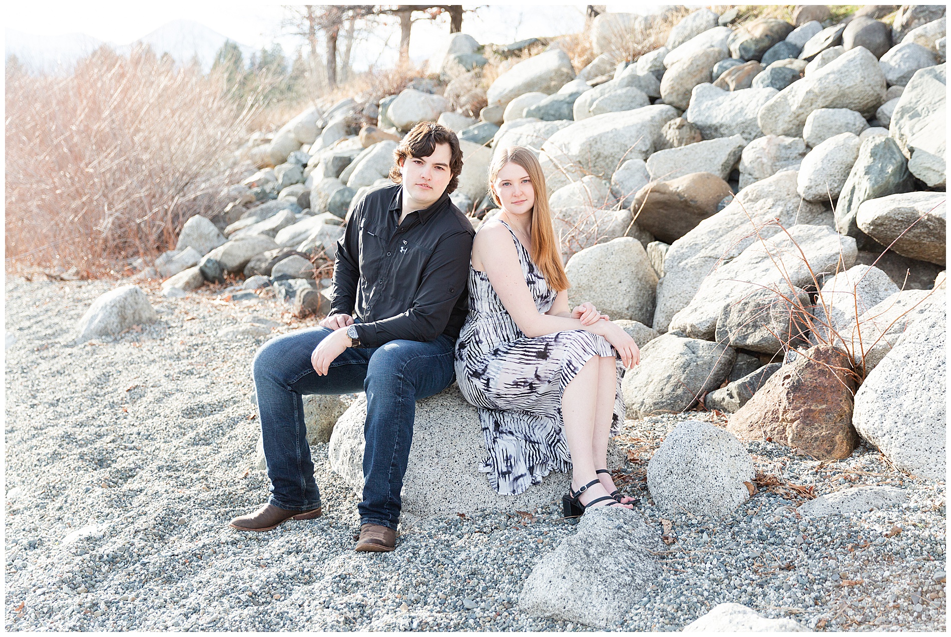 Engaged couple with serious poses on the beach rocks at Wallowa Lake Park