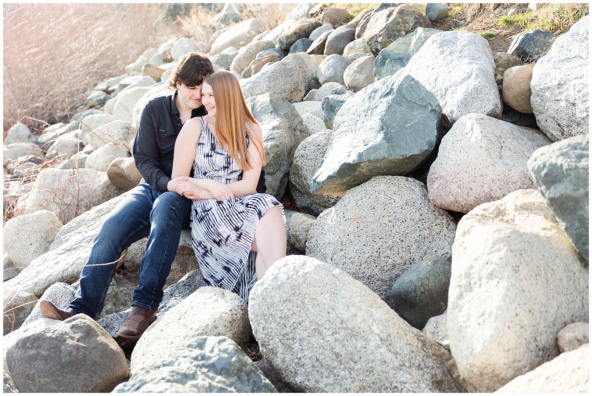 Couple sitting together on the large boulders on the shore of Wallowa Lake