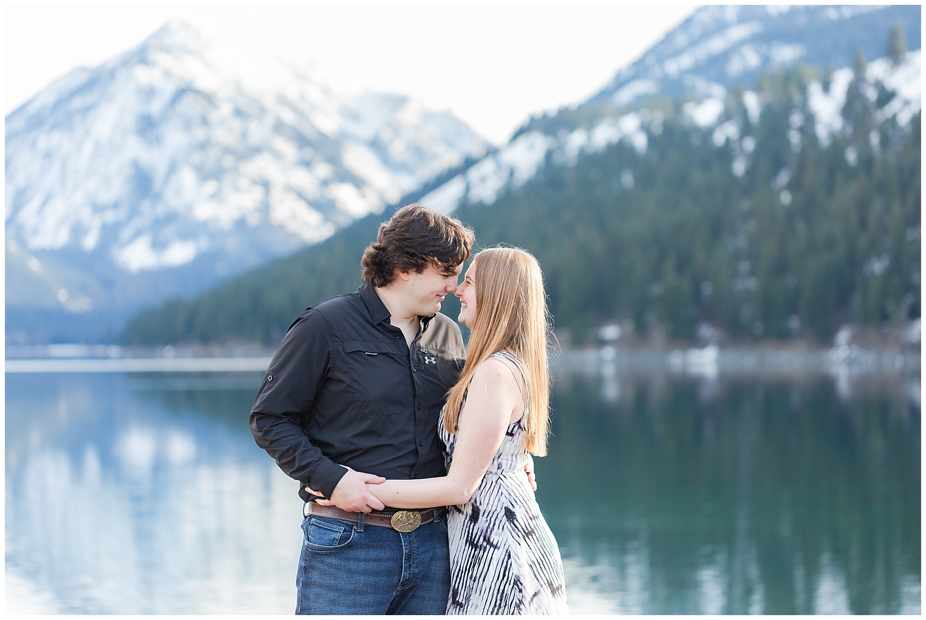 Couple standing close together with Wallowa Mountains behind them
