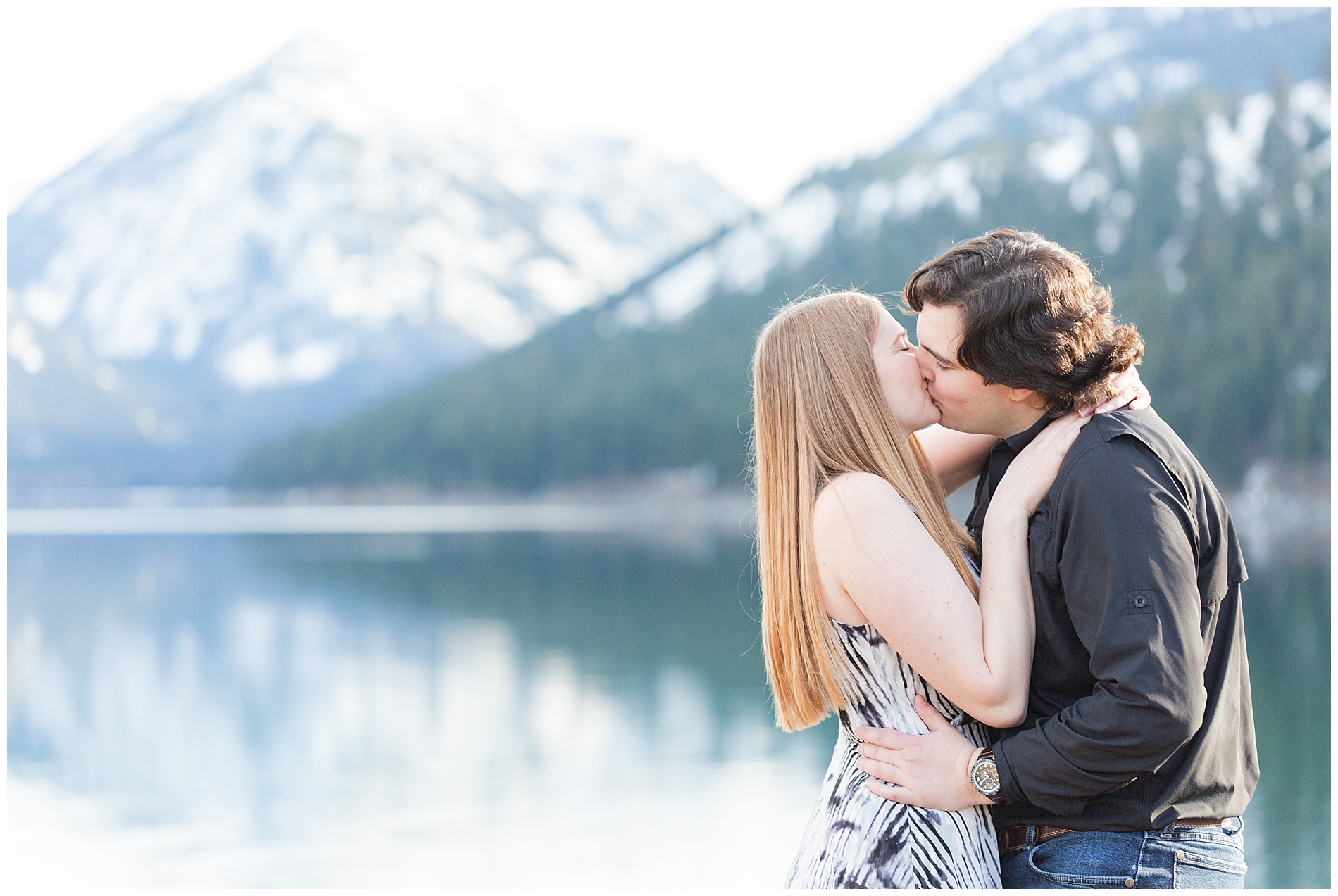 Engaged couple kissing on the shore of Wallowa Lake