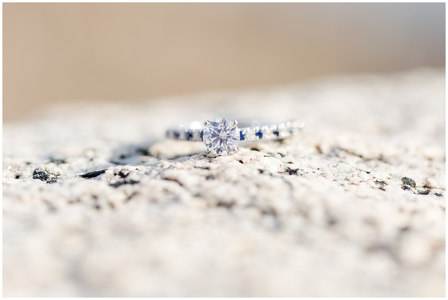 The engagement ring: a round diamond solitaire with alternating white and blue diamonds in the band