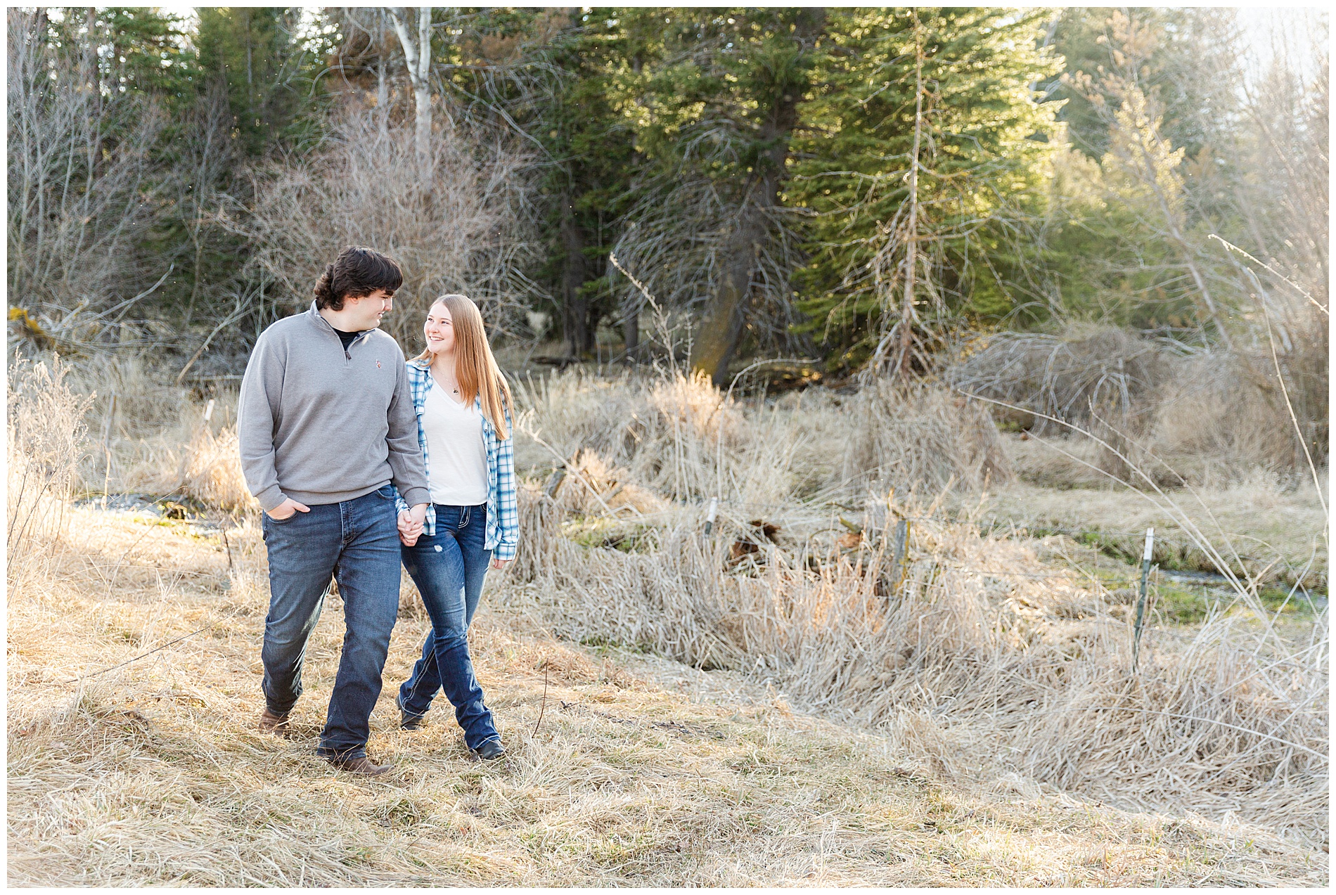 Engaged couple walking together in the trees