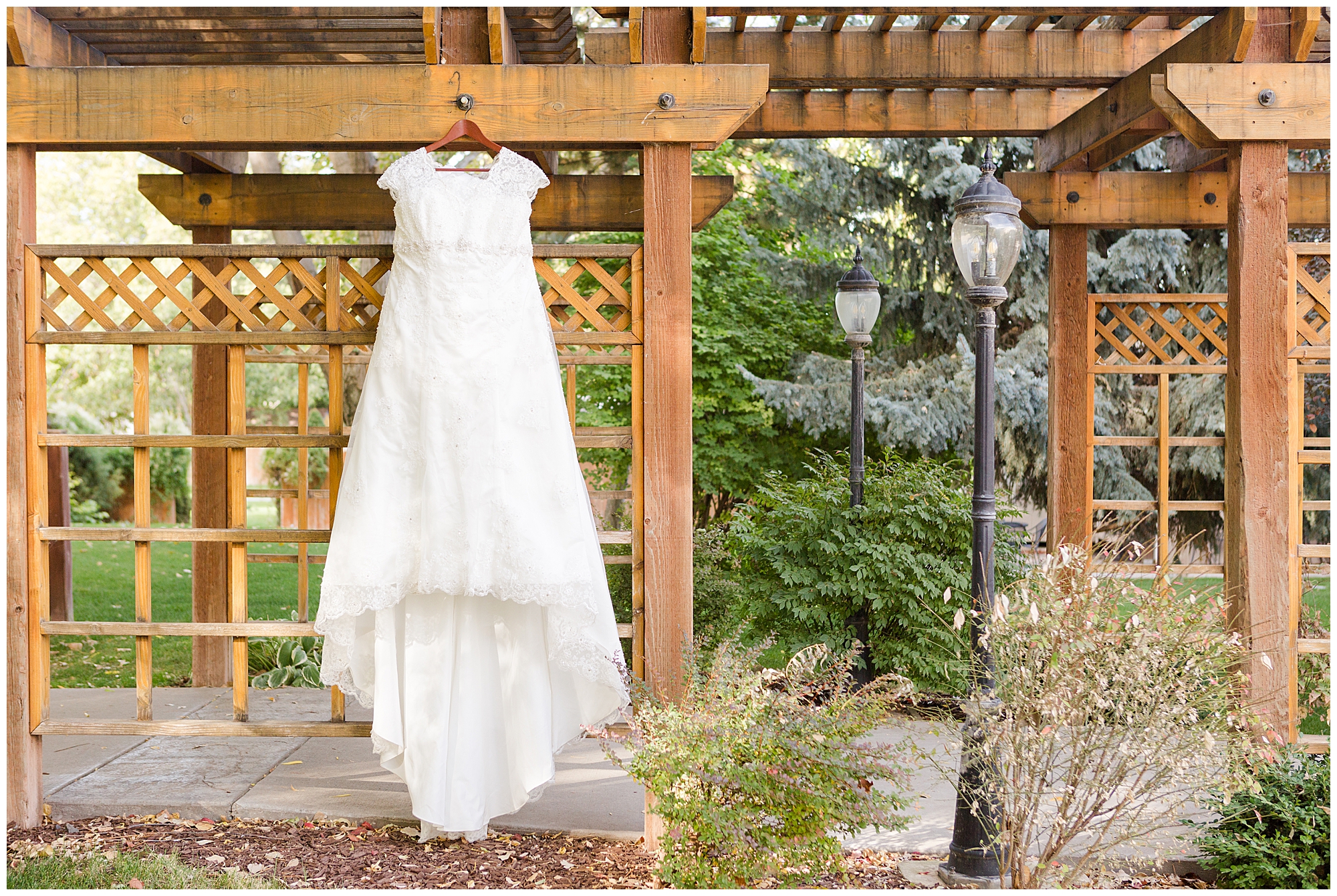 The bride's dress hanging on a wooden arbor at Calvary Chapel in Nampa, Idaho