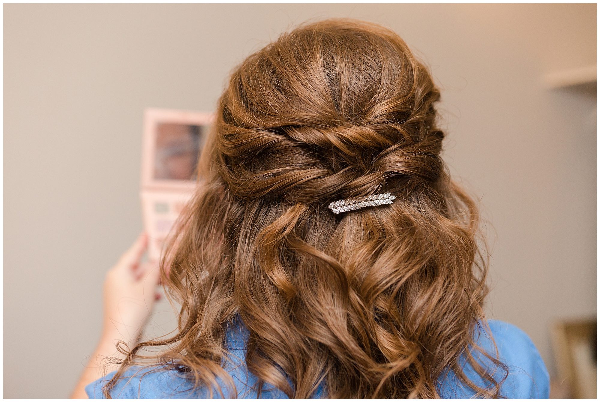 A jewel-studded pin holds the bride's hair in plaice