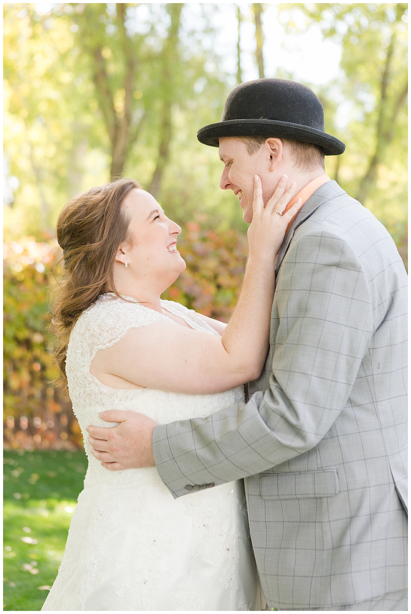 The bride gently touches her groom's face as they embrace