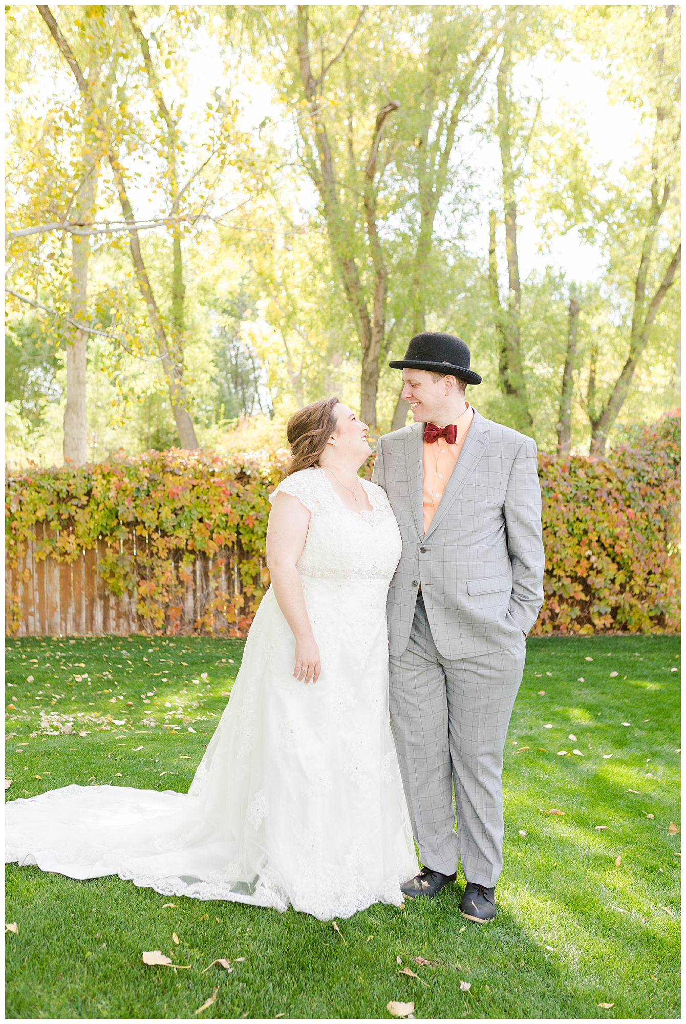 Bride and groom smiling at one another outdoors in October