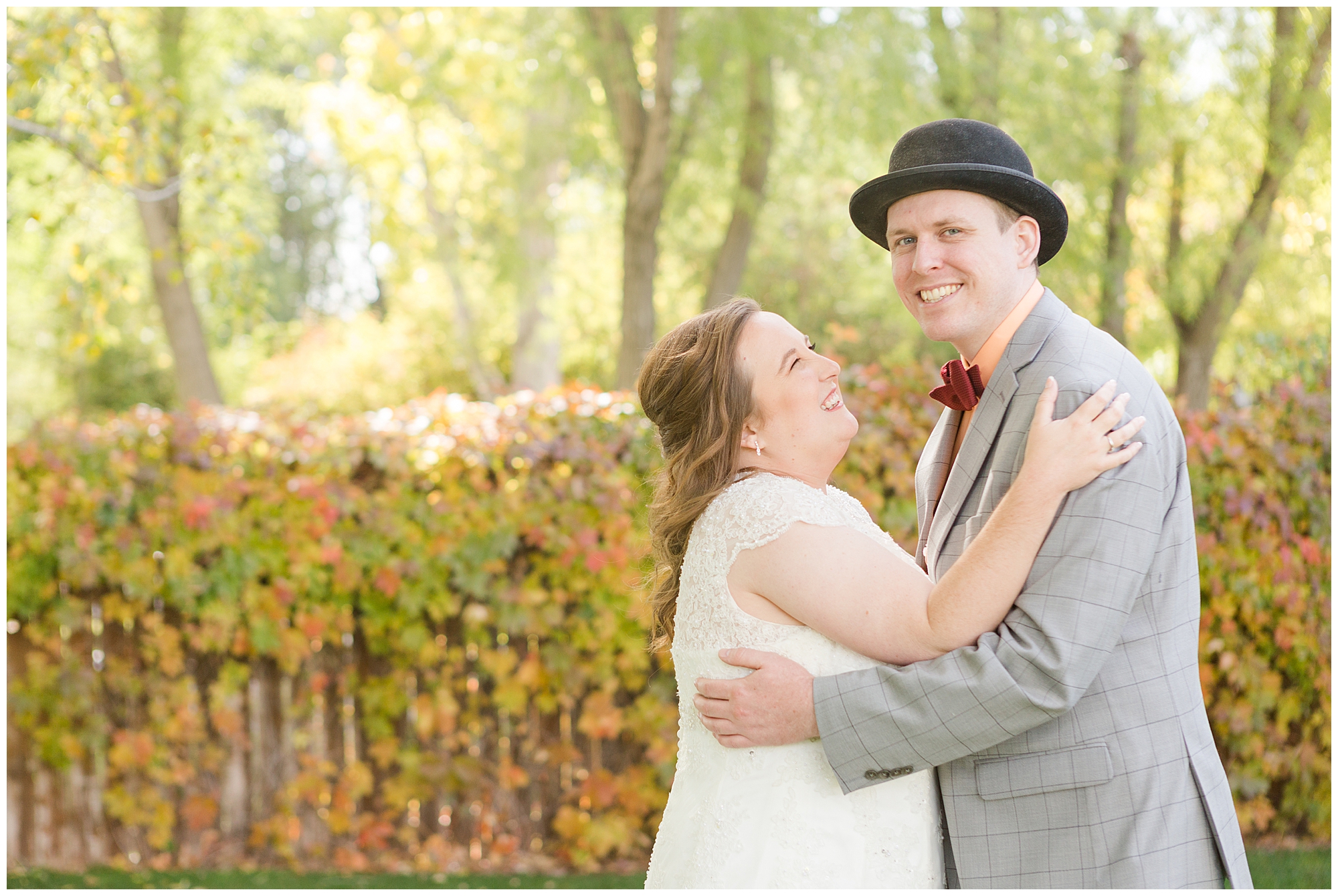 The groom smiling at the camera and his bride is smiling at him