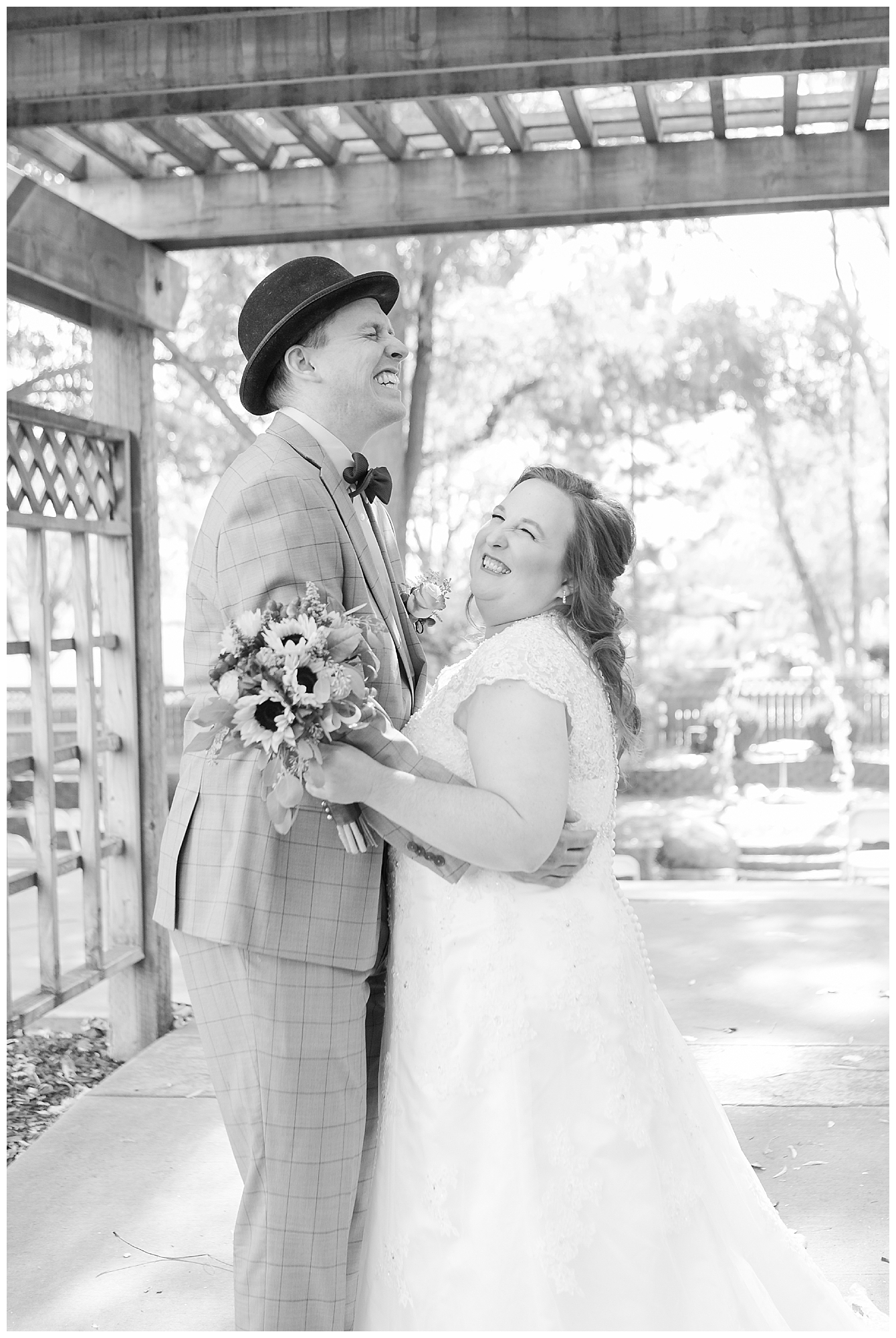 The bride and groom laughing while standing under an arbor at a Nampa Idaho outdoor amphitheater