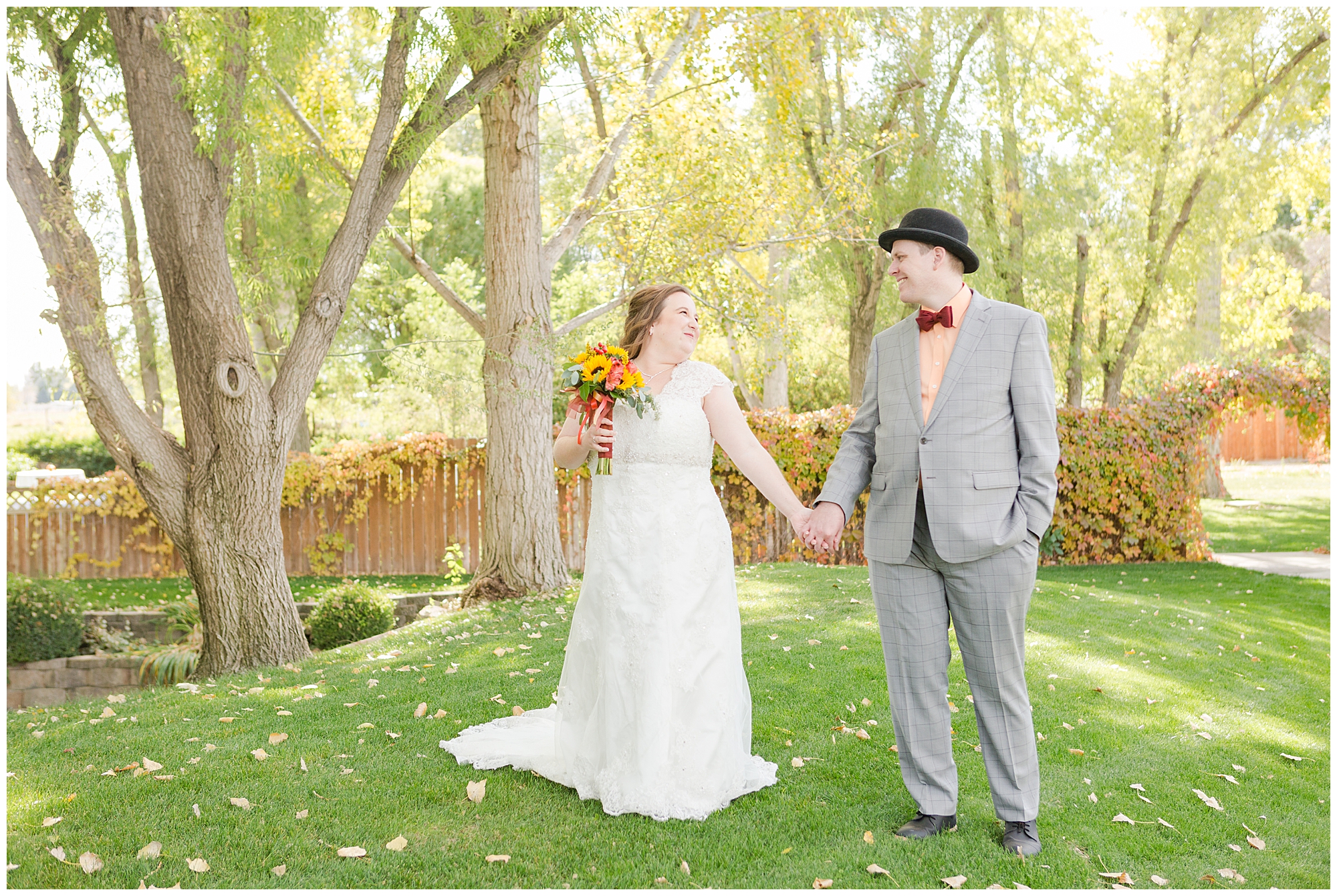 The bride and groom holding hands and smiling at each other