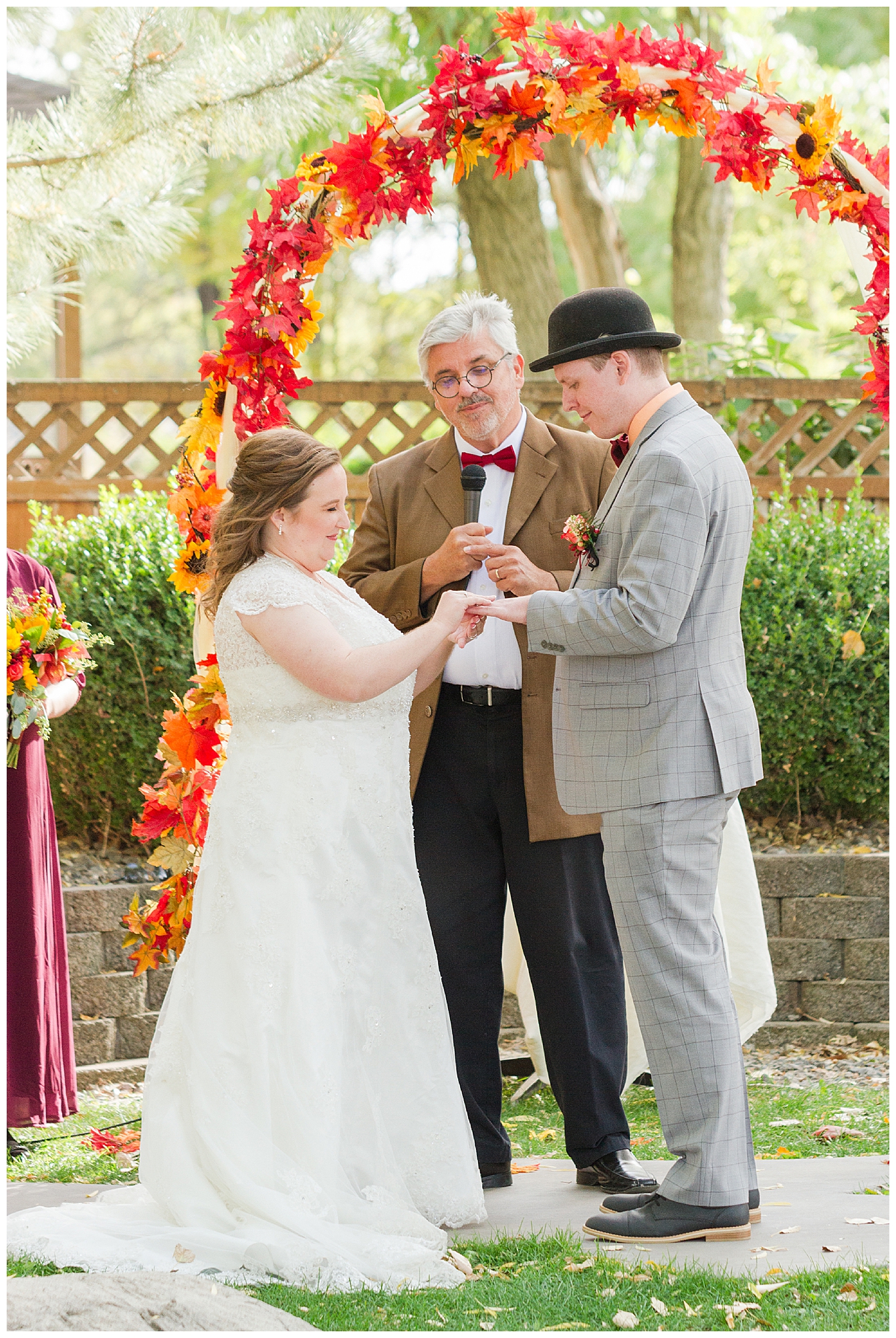 The bride slides the groom's wedding ring onto his finger during the wedding ceremony