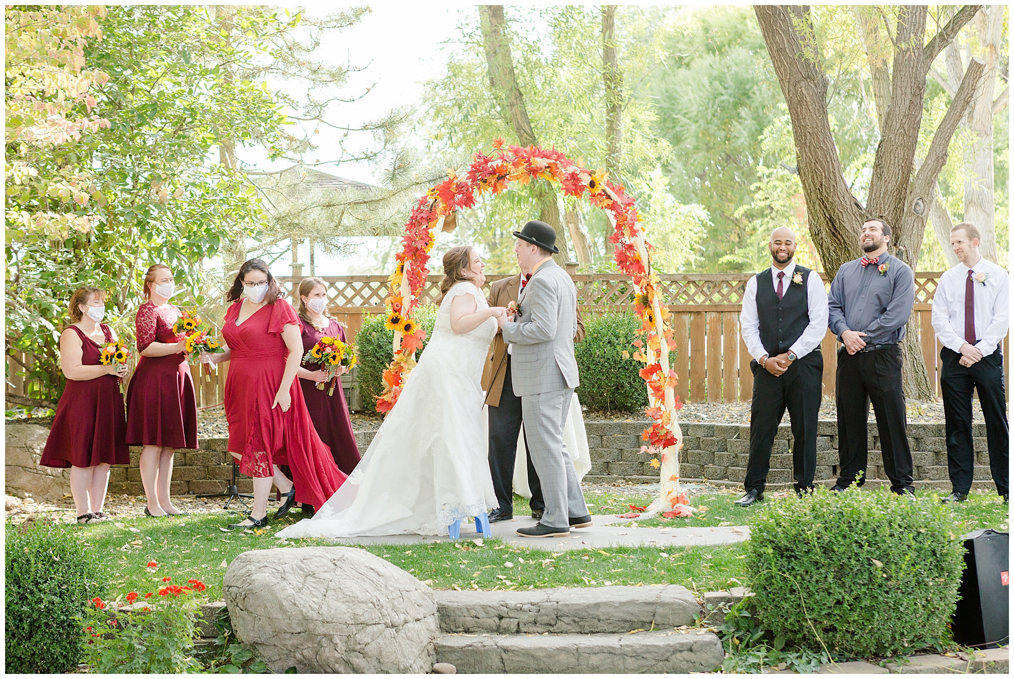 The bridal party laughs after a bridesmaid produced a step stool for the bride, who is very short