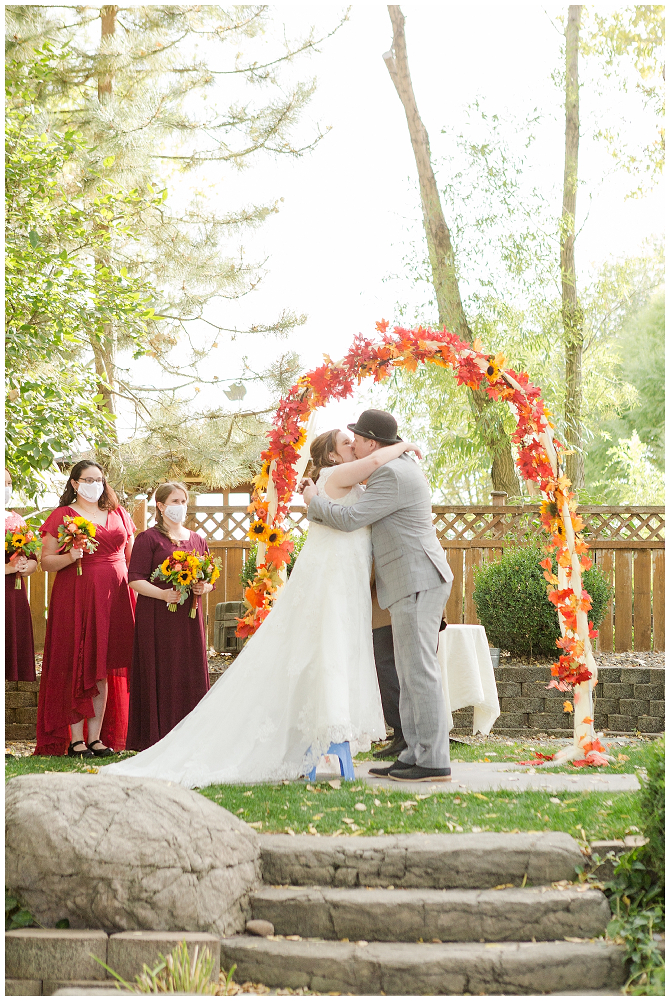 The bride stands on a small step stool to kiss the groom during the wedding ceremony