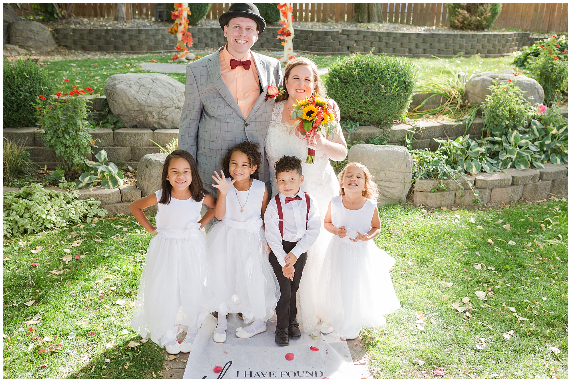 The bride and groom pose with their ring bearer and three flower girls