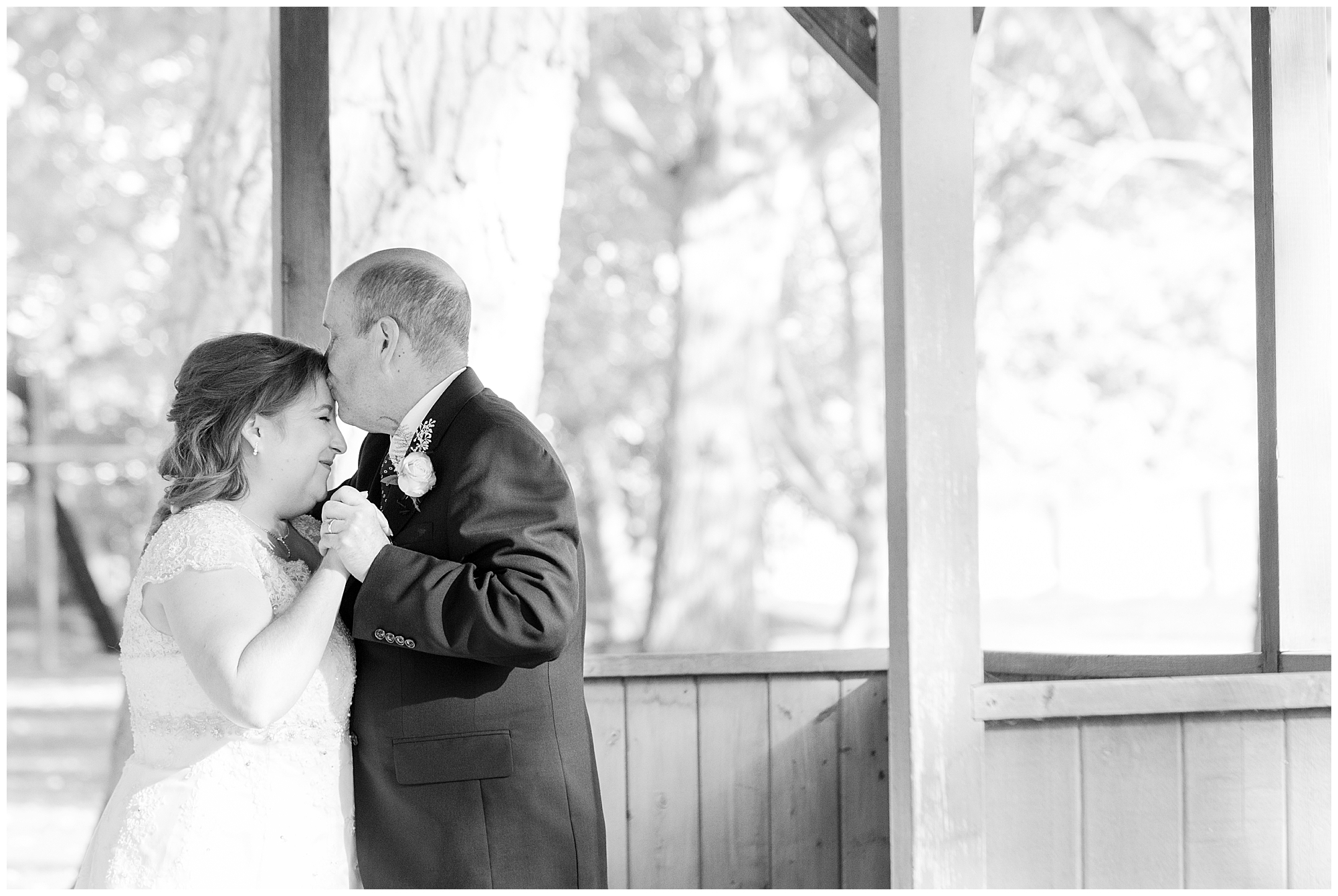 During the father-daughter dance, the bride's father kissed her forehead