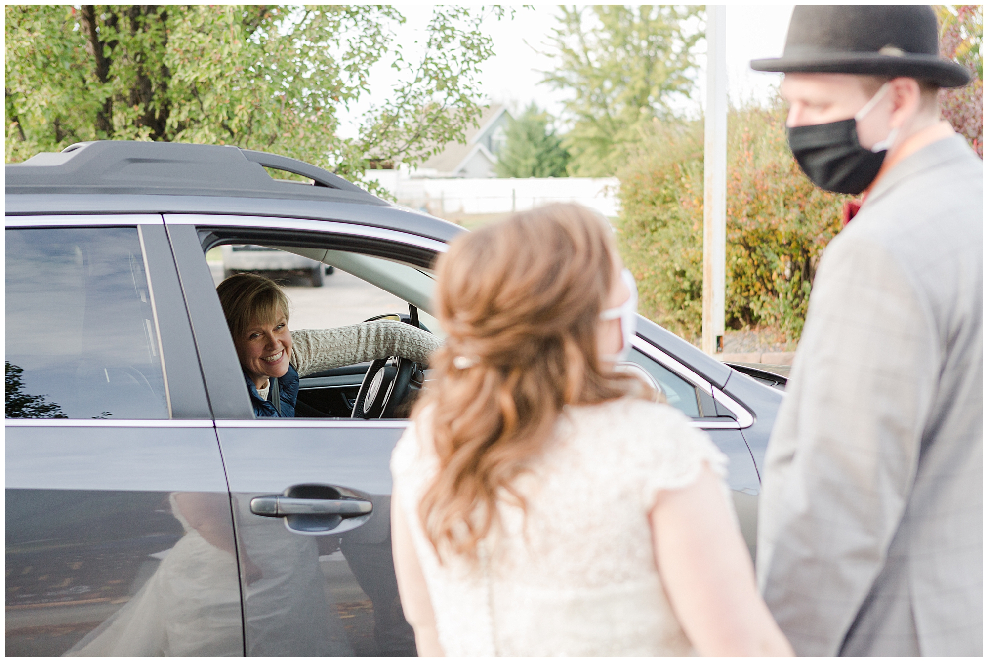 The bride and groom greet their guests at a drive-through reception in Nampa, Idaho