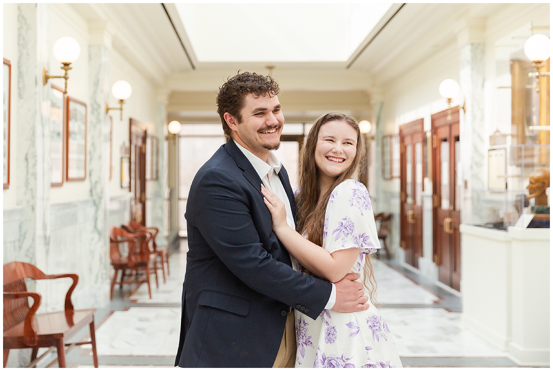 The couple laughing while standing in a hallway at the Capitol
