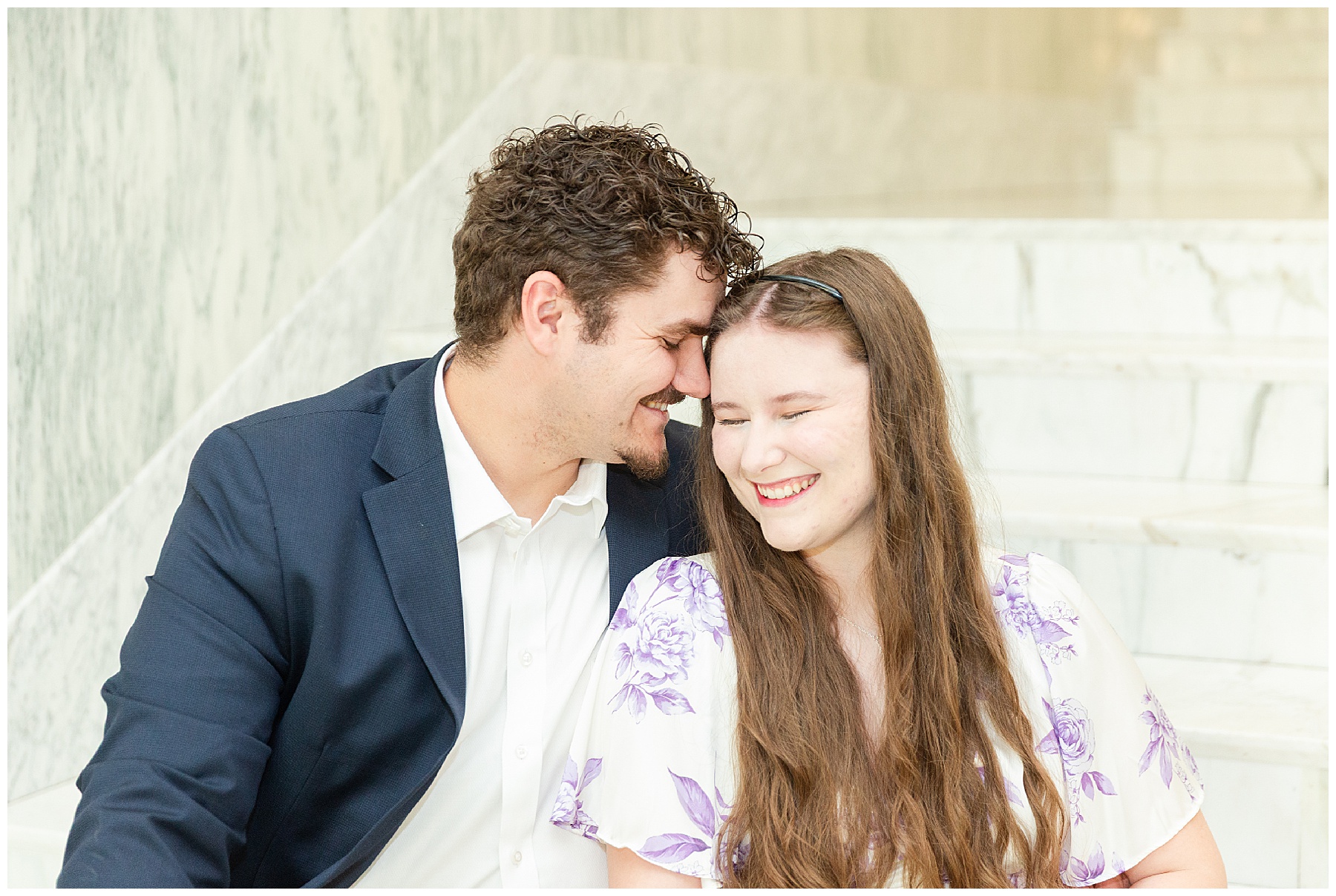 The couple laughing together on the marble steps
