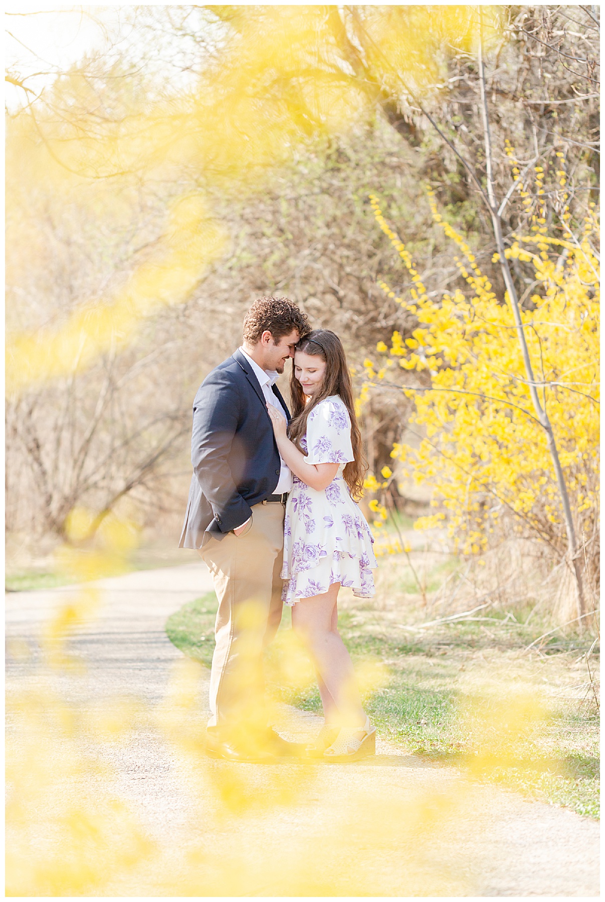 A portrait of the engaged couple through a forsythia bush