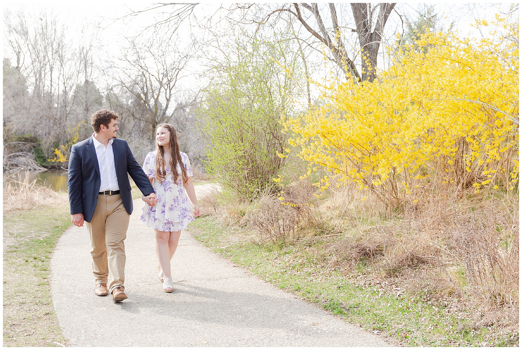 An engaged couple walking together in Albertson Park in spring